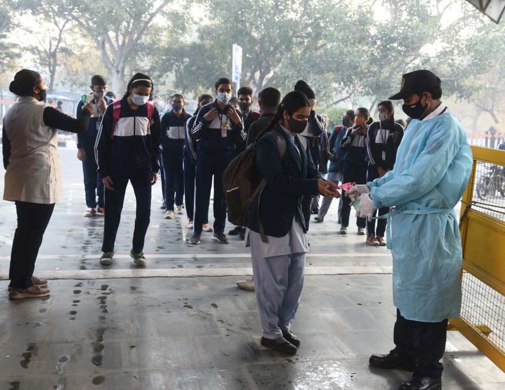 New Delhi: Students undergo thermal screening and are given hand sanitizer as they arrive to attend their class at SKV School, after authorities allowed schools to reopen for the nursery to class 8th following Covid-19 protocols, in New Delhi on Monday, February 14, 2022. (Photo: IANS/Qamar Sibtain)